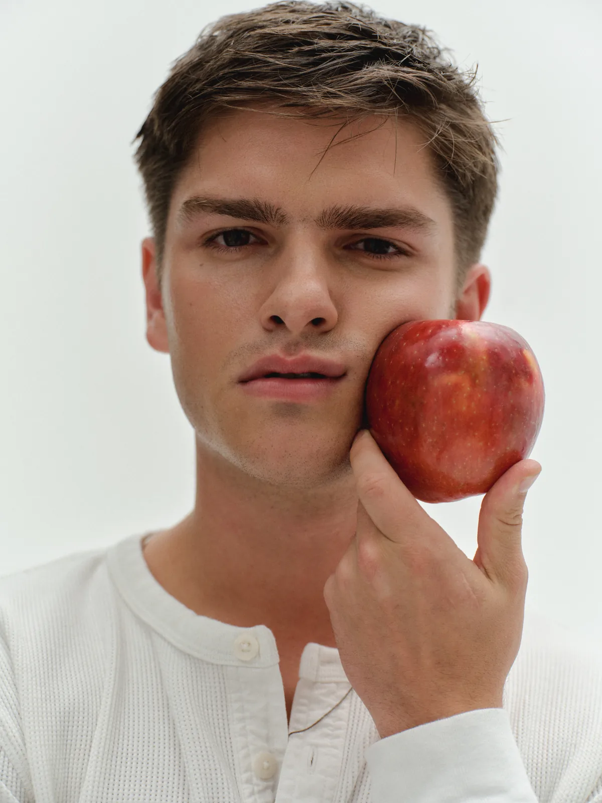 A man holding an apple beside his face as a whole-body health visual