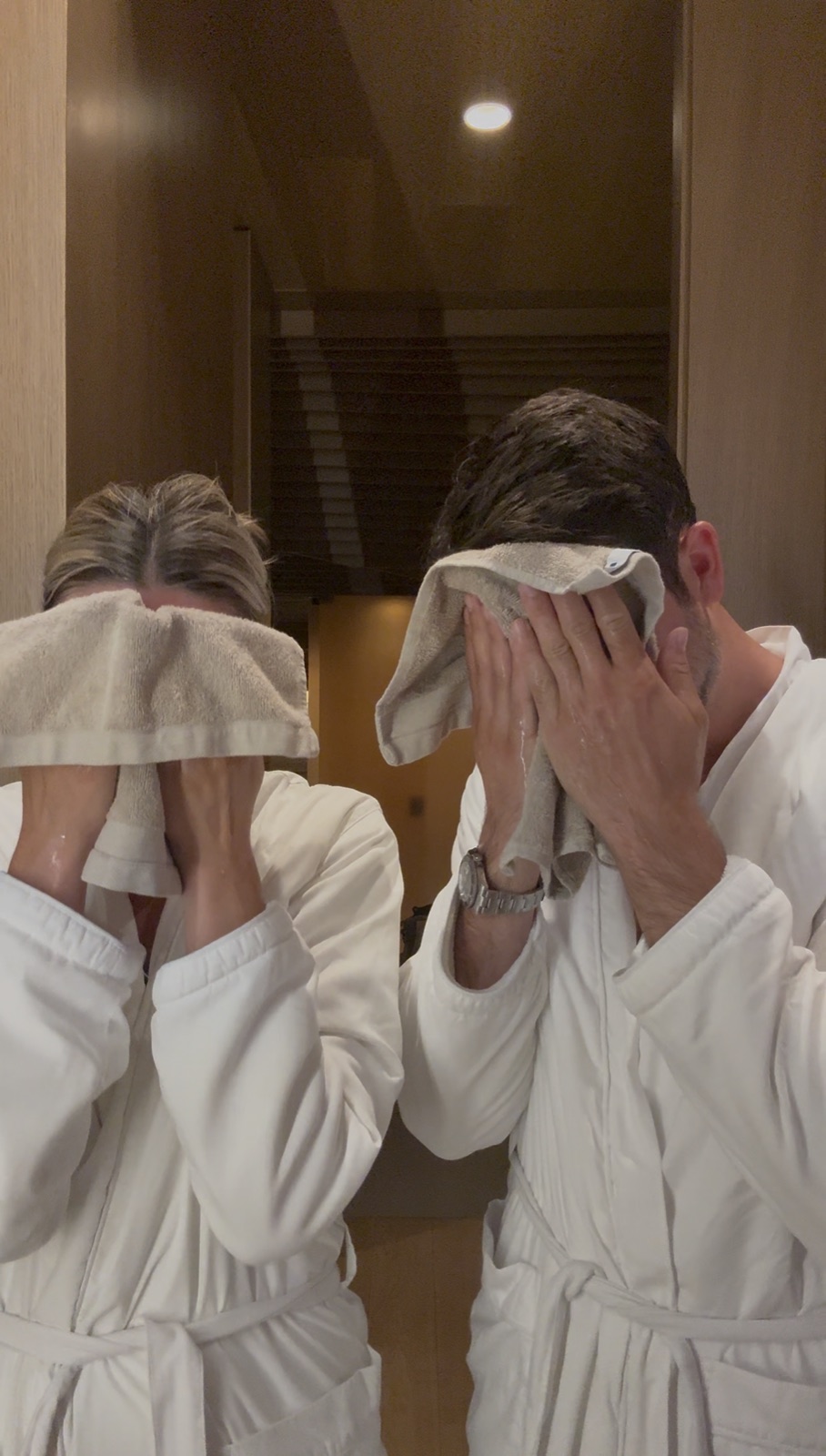 Couple drying their faces together during a shared skincare routine