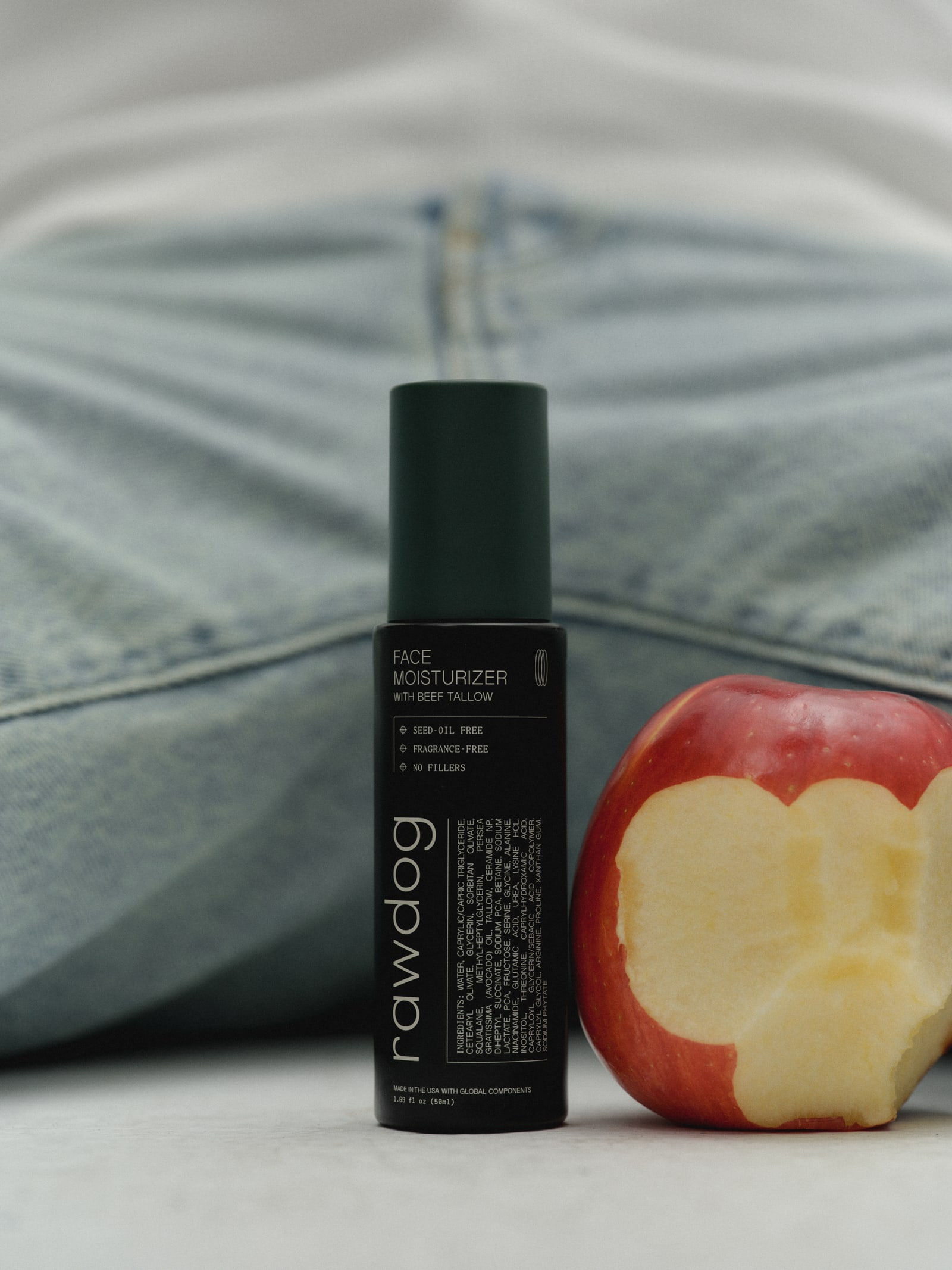 RAWDOG Face Moisturizer with Beef Tallow beside a bitten apple